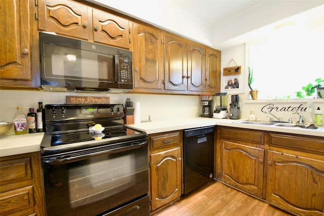832 N 62nd St, Waco, TX 76710 - kitchen featuring black appliances, a sink, light wood-style flooring, and light countertops