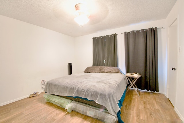 832 N 62nd St, Waco, TX 76710 - bedroom with light wood-style floors, baseboards, a textured ceiling, and ceiling fan