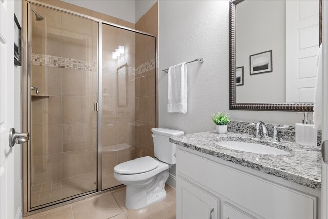 2451 S Gate Dr, Richardson, TX 75080 - full bathroom featuring vanity, a stall shower, toilet, tile patterned floors, and a textured wall