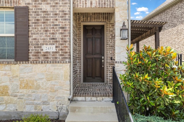 2451 S Gate Dr, Richardson, TX 75080 - property entrance featuring stone siding, a pergola, and brick siding