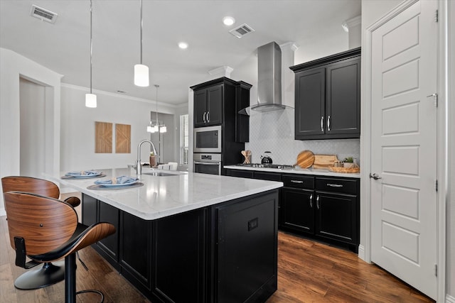 2451 S Gate Dr, Richardson, TX 75080 - kitchen featuring appliances with stainless steel finishes, wall chimney range hood, dark cabinetry, a sink, and crown molding