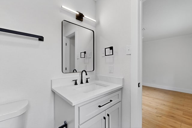 909 Dover Cir, Gainesville, TX 76240 - half bathroom featuring vanity, toilet, and wood finished floors
