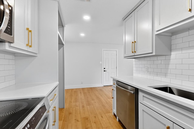 909 Dover Cir, Gainesville, TX 76240 - kitchen featuring stainless steel appliances, light countertops, light wood finished floors, recessed lighting, and tasteful backsplash