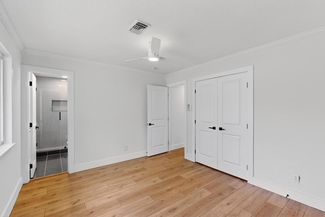 909 Dover Cir, Gainesville, TX 76240 - unfurnished bedroom featuring crown molding, light wood-style floors, baseboards, ensuite bathroom, and a closet