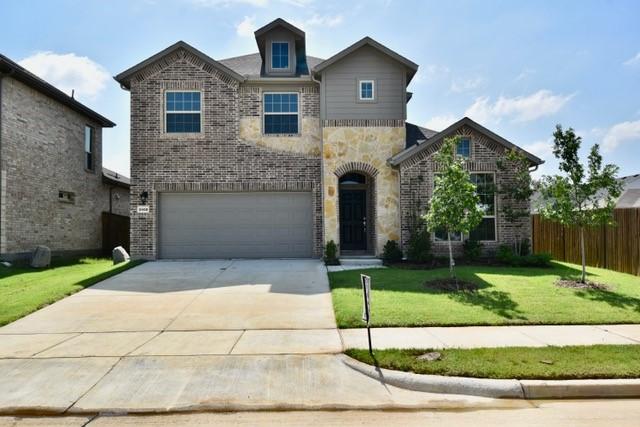 2408 Donella Dr, Denton, TX 76207 - view of front of home featuring an attached garage, driveway, stone siding, and brick siding