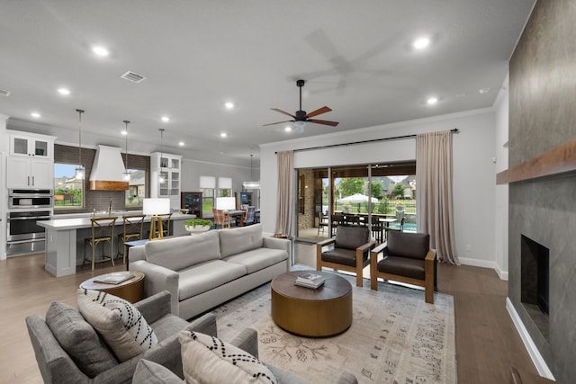 7800 Kentmere, The Colony, TX 75056 - living area with a ceiling fan, light wood-style floors, recessed lighting, crown molding, and a fireplace