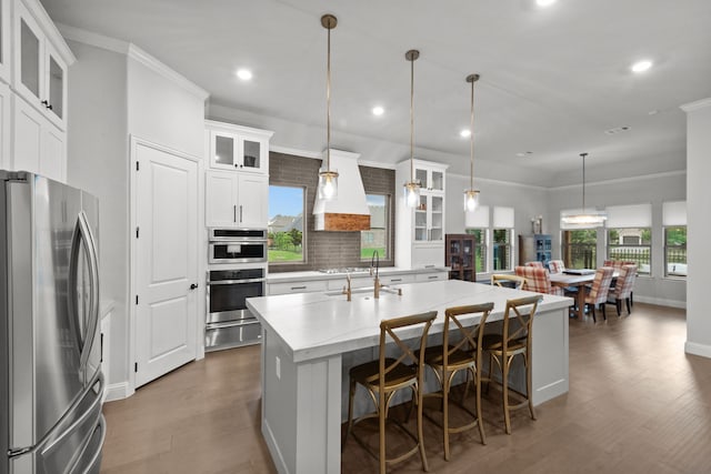 7800 Kentmere, The Colony, TX 75056 - kitchen with stainless steel appliances, custom range hood, a warming drawer, dark wood-style floors, and an island with sink