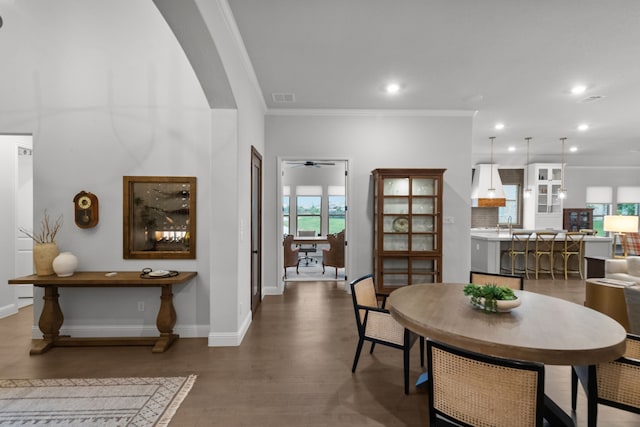 7800 Kentmere, The Colony, TX 75056 - dining space featuring crown molding, arched walkways, wood finished floors, baseboards, and recessed lighting