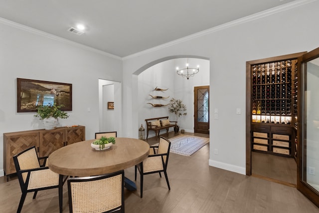 7800 Kentmere, The Colony, TX 75056 - dining room with ornamental molding, wood finished floors, baseboards, arched walkways, and a chandelier