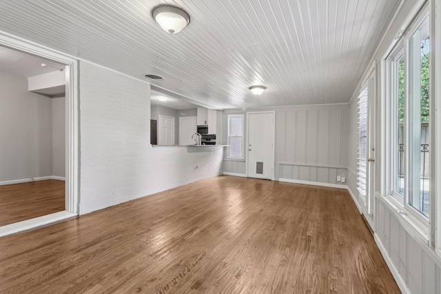 3620 W Biddison St, Fort Worth, TX 76109 - unfurnished living room with wood finished floors, wooden ceiling, and a decorative wall