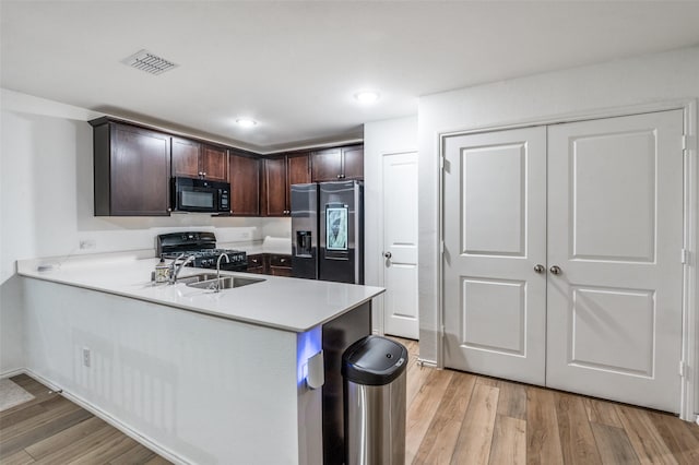 3113 Harper St, Little Elm, TX 75068 - kitchen with black appliances, a sink, dark brown cabinetry, light wood-style floors, and light countertops