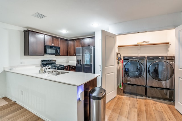 3113 Harper St, Little Elm, TX 75068 - kitchen featuring black appliances, washing machine and clothes dryer, dark brown cabinetry, light wood-type flooring, and light countertops