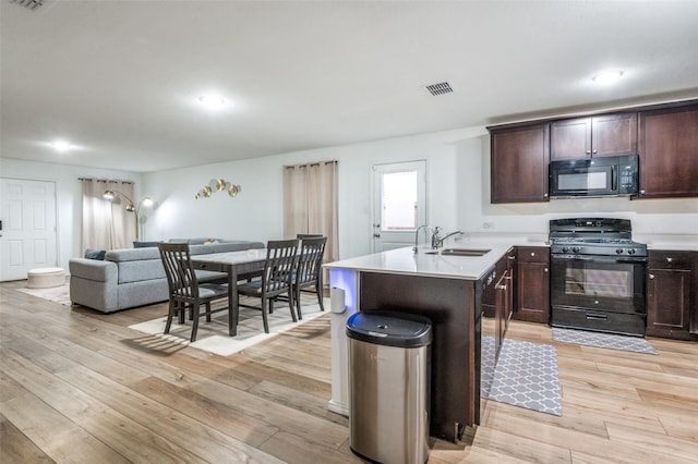 3113 Harper St, Little Elm, TX 75068 - kitchen featuring black appliances, a sink, dark brown cabinetry, a peninsula, and open floor plan