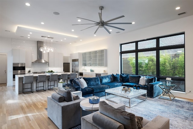6420 Azalea Ln, Dallas, TX 75230 - living room featuring light wood-type flooring, recessed lighting, a ceiling fan, a chandelier, and a high ceiling