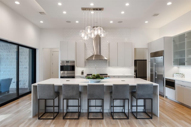 6420 Azalea Ln, Dallas, TX 75230 - kitchen featuring appliances with stainless steel finishes, modern cabinets, wall chimney exhaust hood, a towering ceiling, and recessed lighting