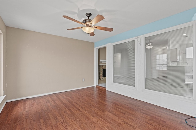 1100 Cedarcrest Dr, Mesquite, TX 75149 - empty room with ceiling fan, wood finished floors, baseboards, and a fireplace
