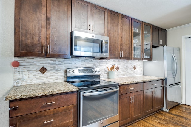 6616 Elvedon Dr, Dallas, TX 75248 - kitchen featuring stainless steel appliances, decorative backsplash, dark wood-type flooring, glass insert cabinets, and ornamental molding
