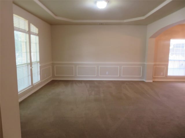 1501 Mountain Laurel Ln, Desoto, TX 75115 - carpeted empty room with arched walkways, a decorative wall, wainscoting, and a raised ceiling