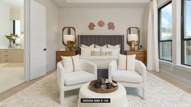 712 Bear Creek Dr, Hurst, TX 76054 - bedroom with connected bathroom, baseboards, and light wood-style flooring