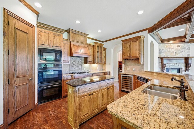 49 Pristine Pond Dr, Frisco, TX 75034 - kitchen with beverage cooler, black appliances, crown molding, light stone countertops, and arched walkways