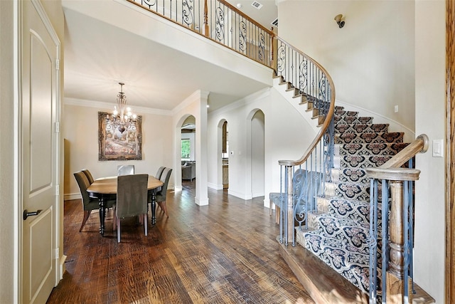 49 Pristine Pond Dr, Frisco, TX 75034 - dining area featuring a chandelier, arched walkways, crown molding, dark wood-style flooring, and stairs