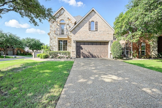 49 Pristine Pond Dr, Frisco, TX 75034 - french country home featuring an attached garage, concrete driveway, a balcony, brick siding, and stone siding