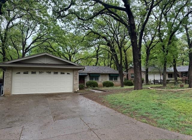 single story home featuring concrete driveway, an attached garage, brick siding, and a front lawn