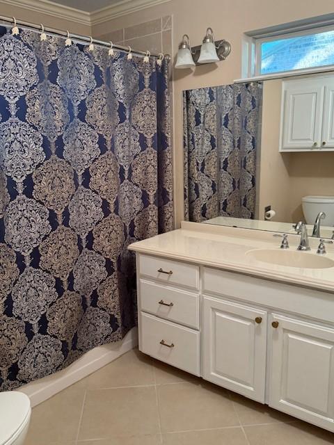full bathroom featuring tile patterned flooring, vanity, ornamental molding, and curtained shower