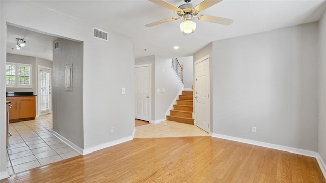 3901 Travis St Unit 230, Dallas, TX 75204 - spare room featuring light wood-style flooring, stairs, ceiling fan, and baseboards