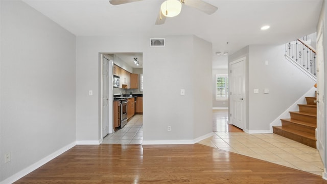 3901 Travis St Unit 230, Dallas, TX 75204 - empty room with stairs, ceiling fan, light tile patterned flooring, and baseboards