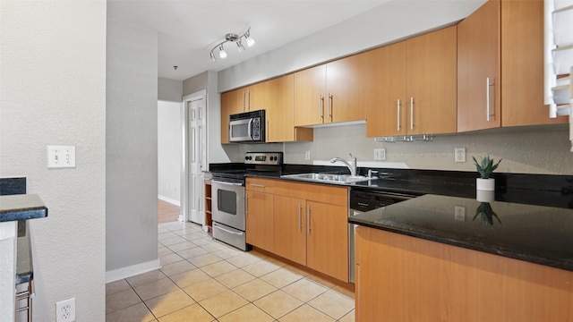 3901 Travis St Unit 230, Dallas, TX 75204 - kitchen featuring stainless steel appliances, light tile patterned floors, a sink, and baseboards