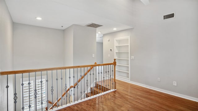 3901 Travis St Unit 230, Dallas, TX 75204 - hall with wood finished floors, an upstairs landing, baseboards, built in shelves, and recessed lighting