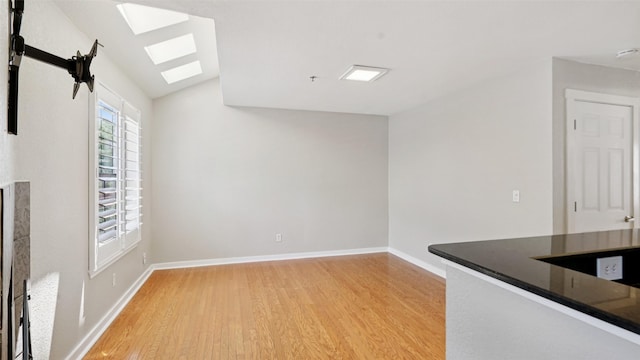 3901 Travis St Unit 230, Dallas, TX 75204 - interior space featuring a skylight, light wood finished floors, vaulted ceiling, and baseboards