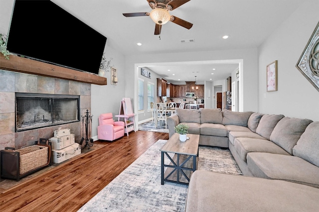 3006 Preston Club Dr, Sherman, TX 75092 - living room with wood finished floors, a ceiling fan, a tiled fireplace, recessed lighting, and baseboards