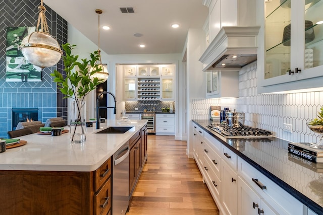 2203 Steed Run Dr, Mansfield, TX 76063 - kitchen featuring premium range hood, a sink, stainless steel appliances, beverage cooler, and light wood-style floors