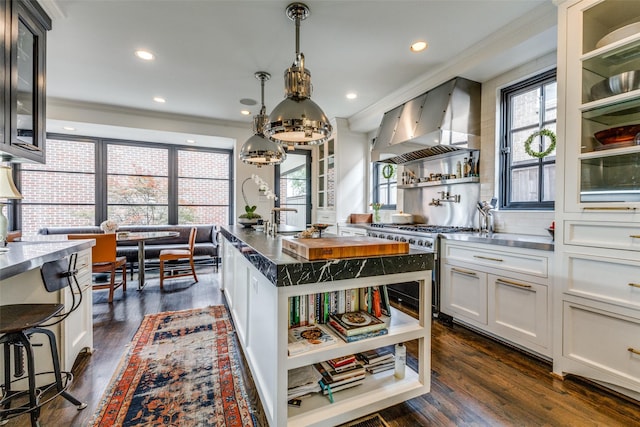 4205 Bryn Mawr Dr, University Park, TX 75225 - kitchen featuring wall chimney exhaust hood, dark wood-style floors, a chandelier, glass insert cabinets, and ornamental molding