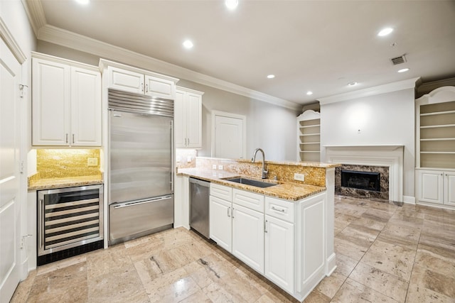 4240 Prescott Ave Unit 5B, Dallas, TX 75219 - kitchen with stainless steel appliances, a sink, beverage cooler, a peninsula, and recessed lighting