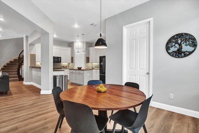 1516 Stonehill Ct, Allen, TX 75002 - dining space with baseboards, light wood-style floors, stairs, and recessed lighting
