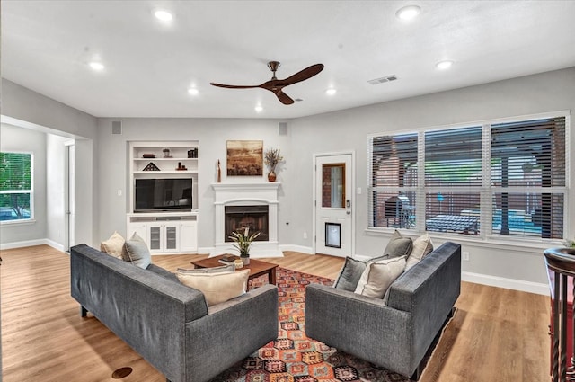 1516 Stonehill Ct, Allen, TX 75002 - living room with a ceiling fan, a fireplace with raised hearth, wood finished floors, baseboards, and recessed lighting