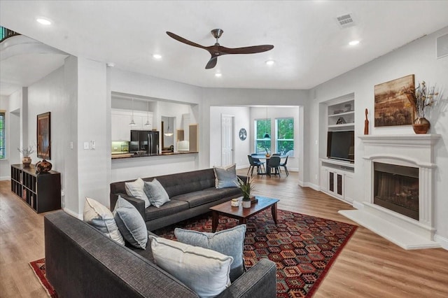 1516 Stonehill Ct, Allen, TX 75002 - living room with ceiling fan, built in shelves, wood finished floors, recessed lighting, and baseboards