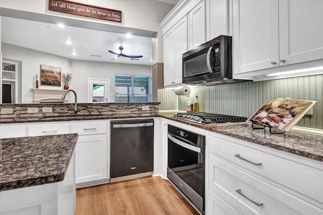 1516 Stonehill Ct, Allen, TX 75002 - kitchen with appliances with stainless steel finishes, a sink, light wood-style flooring, white cabinetry, and dark stone counters