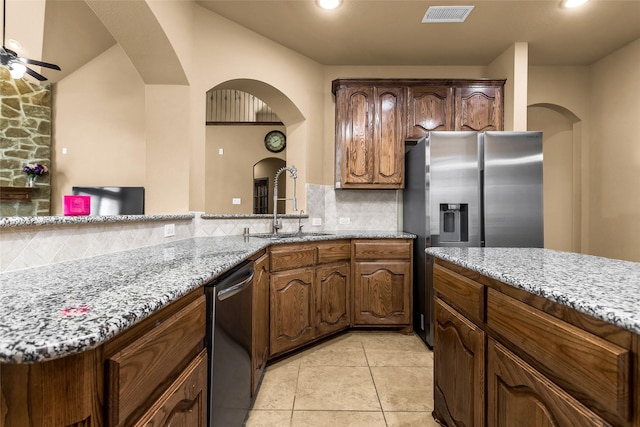 1518 E Oates Rd, Garland, TX 75043 - kitchen featuring appliances with stainless steel finishes, arched walkways, light stone countertops, backsplash, and recessed lighting