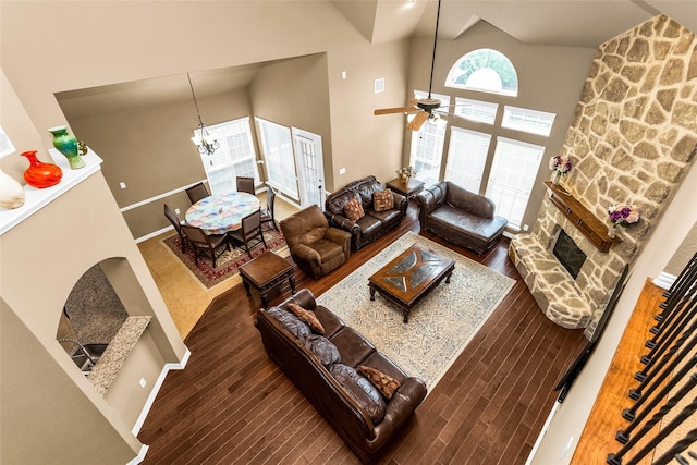 1518 E Oates Rd, Garland, TX 75043 - living room with a stone fireplace, wood finished floors, high vaulted ceiling, a ceiling fan, and a chandelier