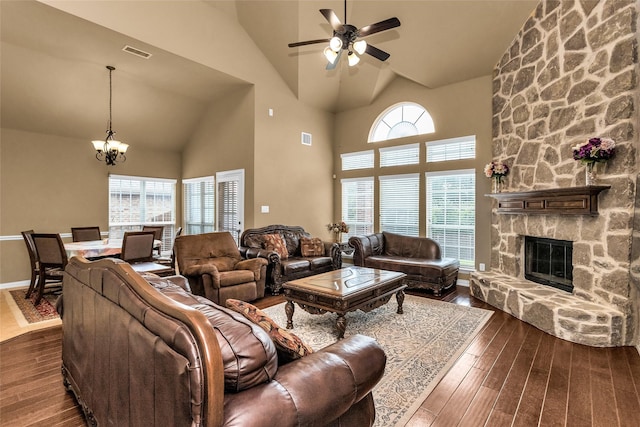 1518 E Oates Rd, Garland, TX 75043 - living area featuring high vaulted ceiling, a chandelier, dark wood-type flooring, a ceiling fan, and a stone fireplace