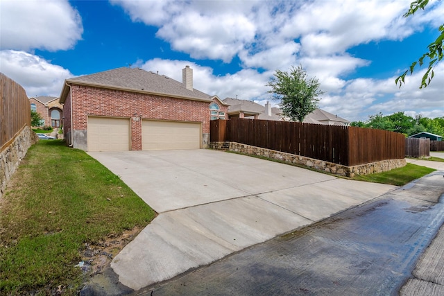 1518 E Oates Rd, Garland, TX 75043 - view of property exterior with a chimney, a garage, driveway, and brick siding