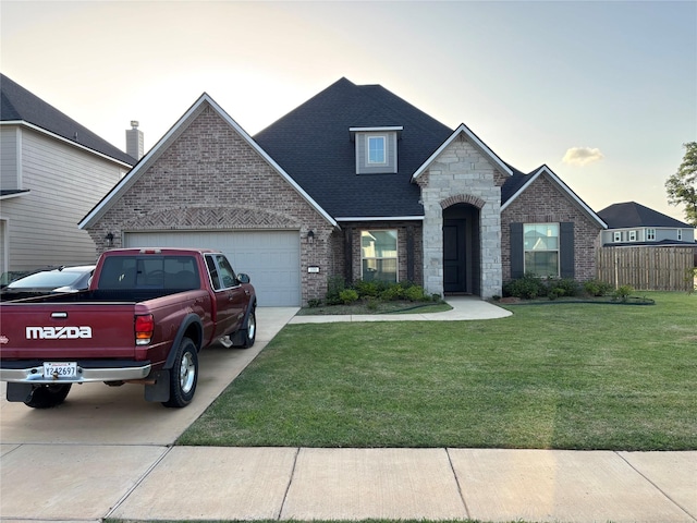 100 Cocodrie Cir, Bossier City, LA 71112 - french country home featuring brick siding, an attached garage, driveway, roof with shingles, and stone siding