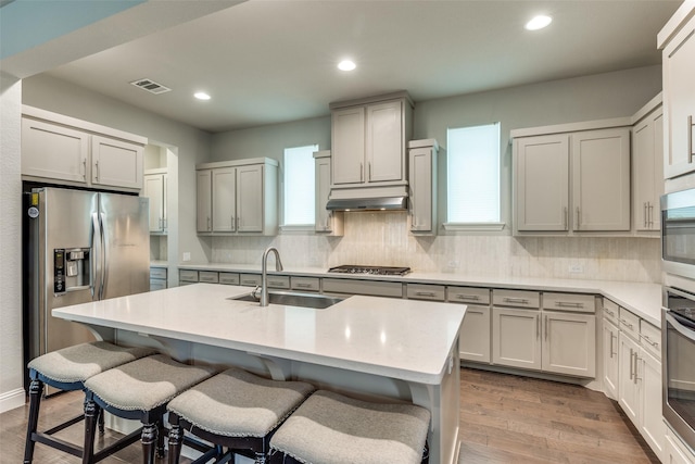 1031 Devonshire Dr, Allen, TX 75013 - kitchen featuring a sink, stainless steel appliances, decorative backsplash, light wood finished floors, and plenty of natural light