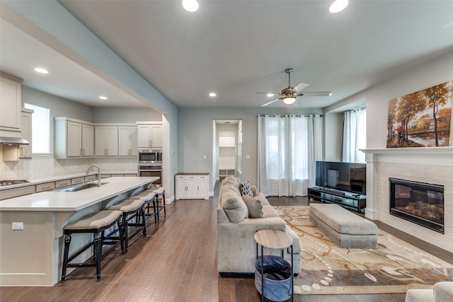 1031 Devonshire Dr, Allen, TX 75013 - living area featuring a ceiling fan, recessed lighting, a tiled fireplace, and wood finished floors