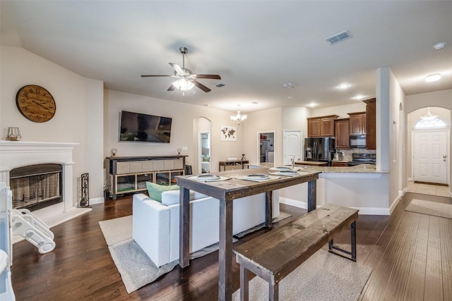 3717 Dutch Iris Ln, Forest Hill, TX 76140 - living area featuring a fireplace with raised hearth, dark wood-style flooring, a ceiling fan, arched walkways, and baseboards