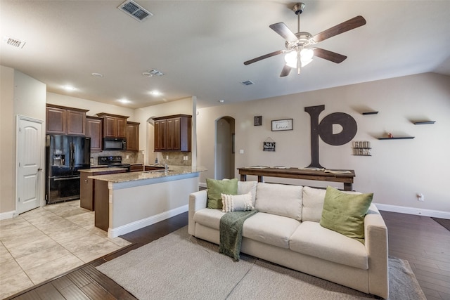 3717 Dutch Iris Ln, Forest Hill, TX 76140 - living room with arched walkways, light wood-type flooring, ceiling fan, and baseboards